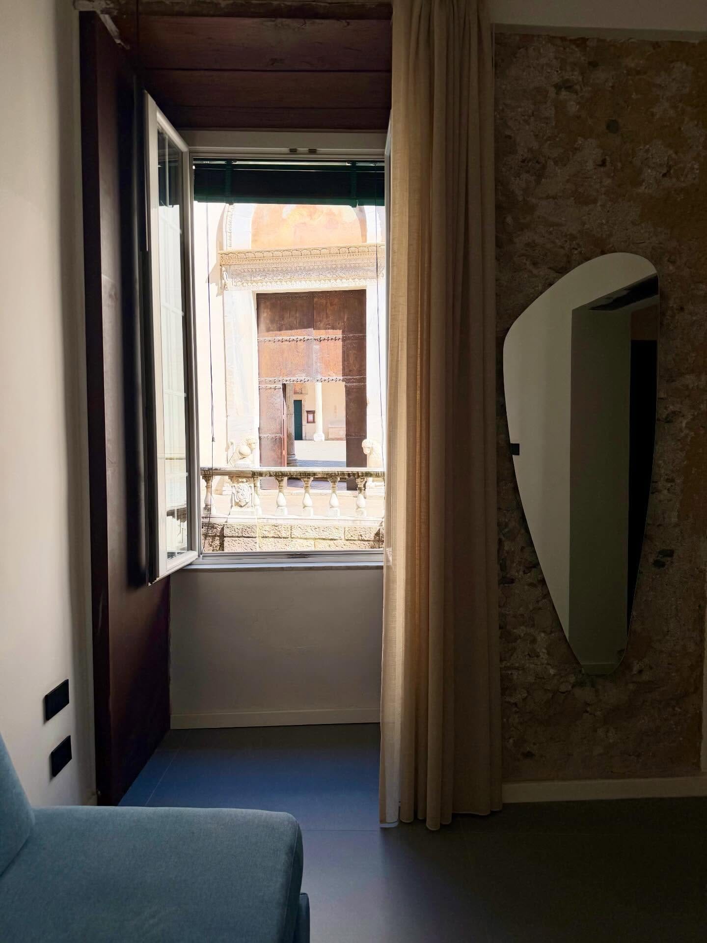 La finestra di una camera aperta sull'atrio del Duomo, con le colonne e la balaustra